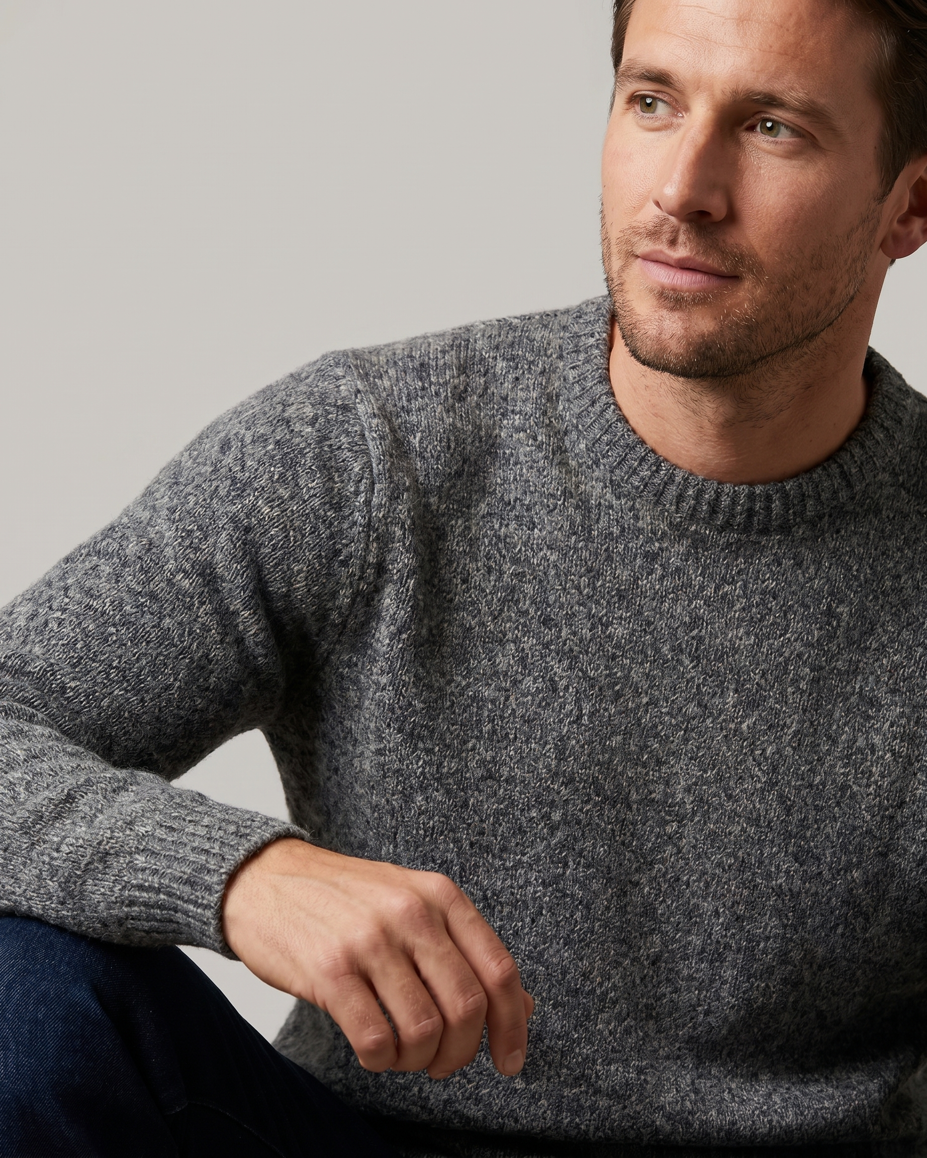 Man wearing a gray sweater against a plain background
