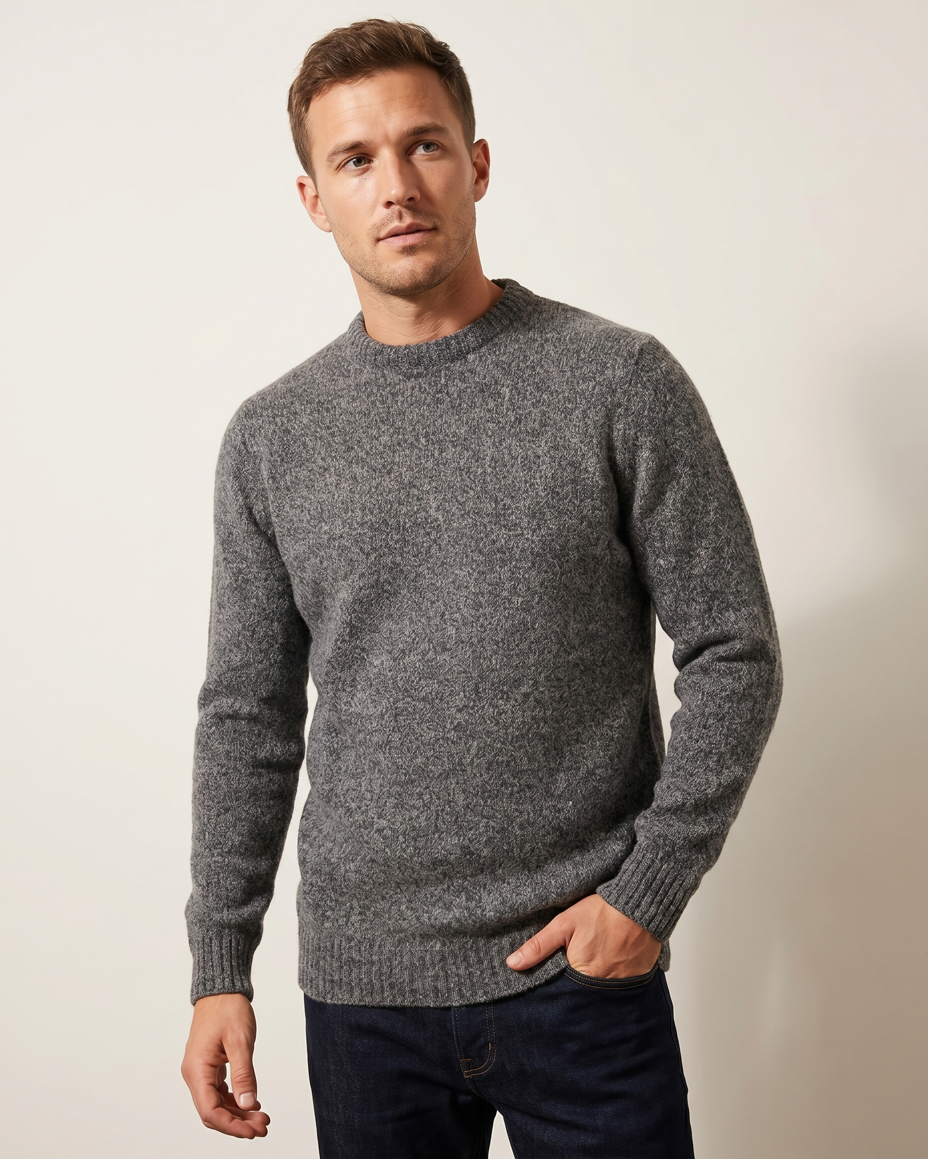 Man wearing a gray sweater against a plain background