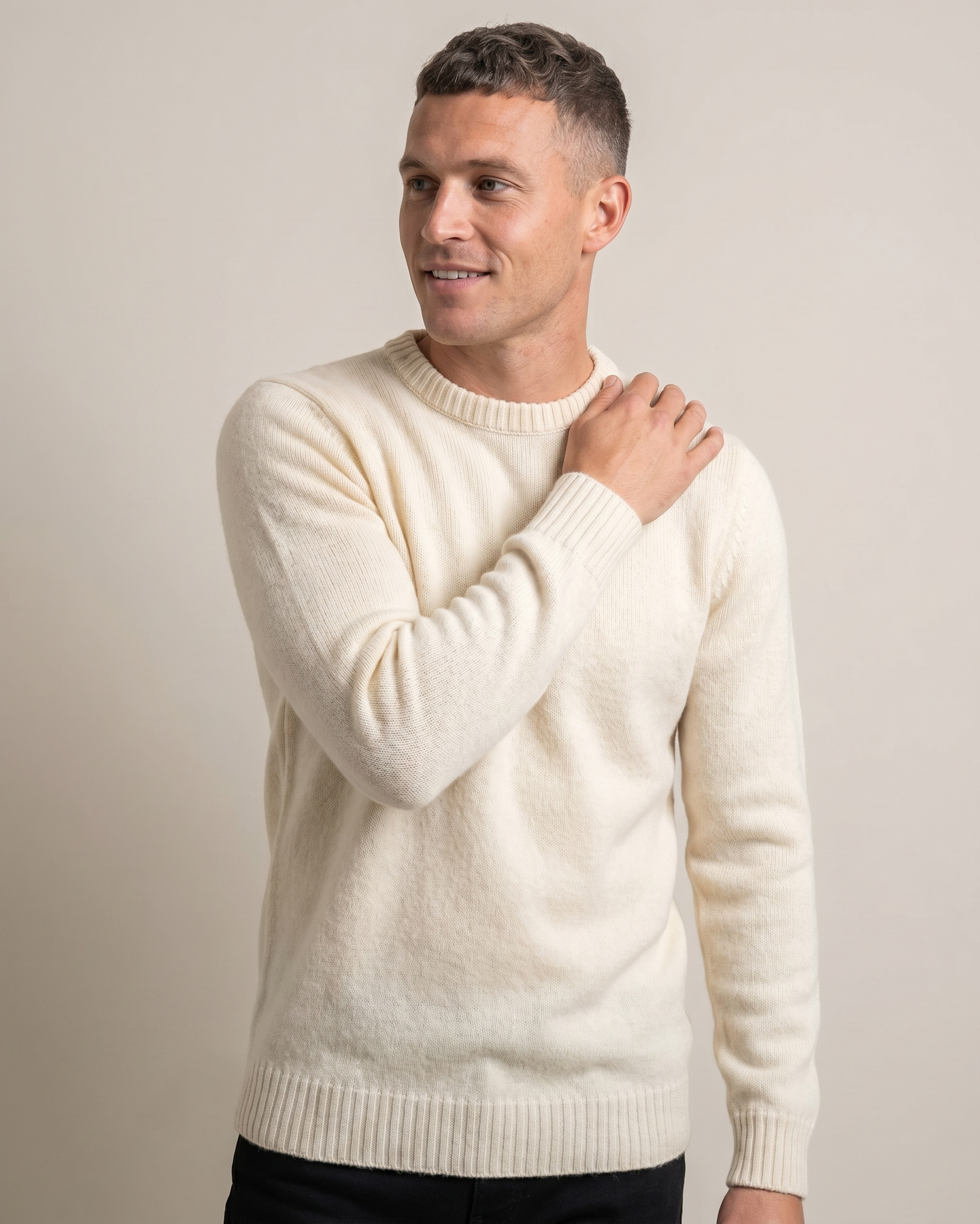 Man wearing a cream sweater against a plain background
