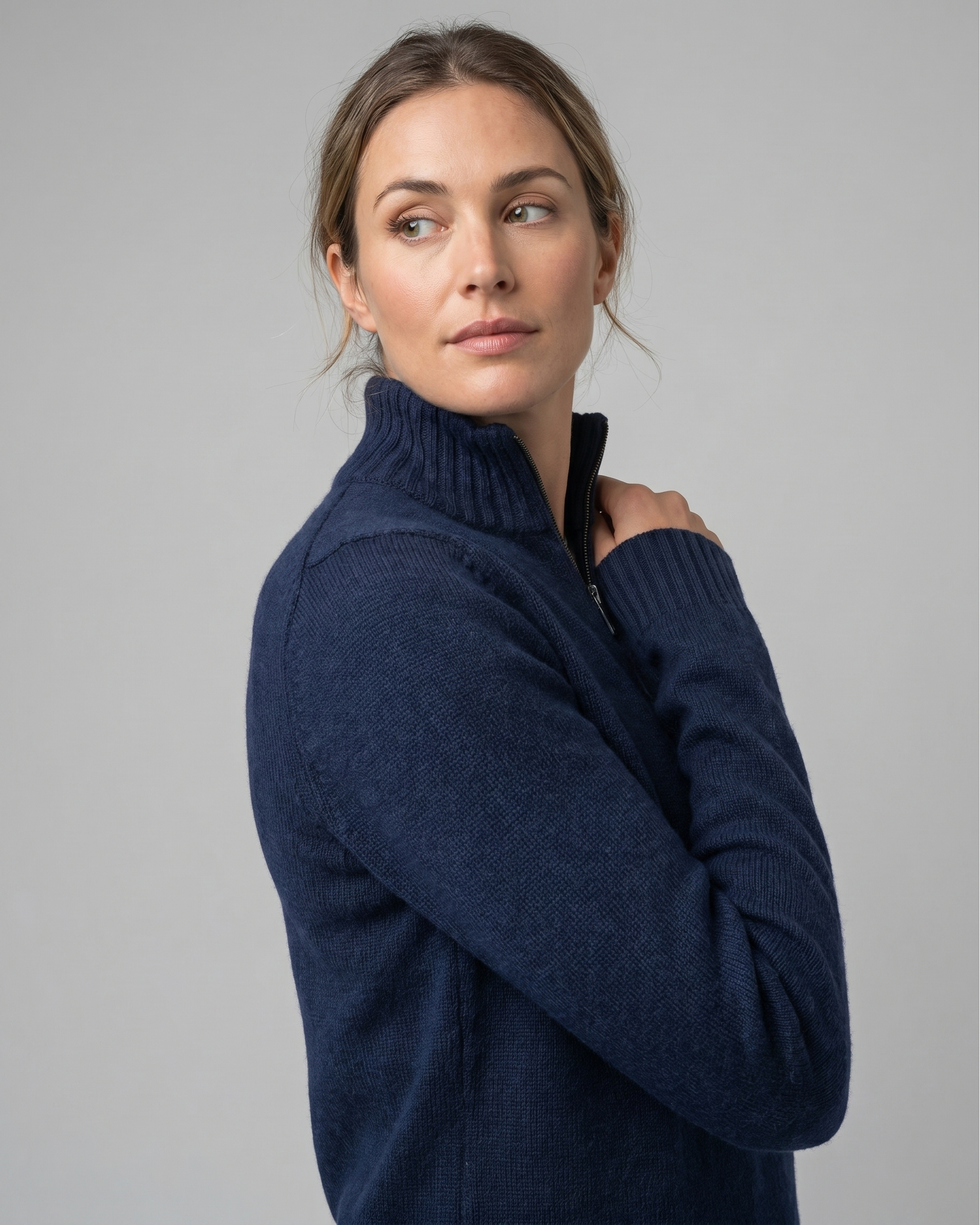Woman wearing a navy blue sweater against a gray background