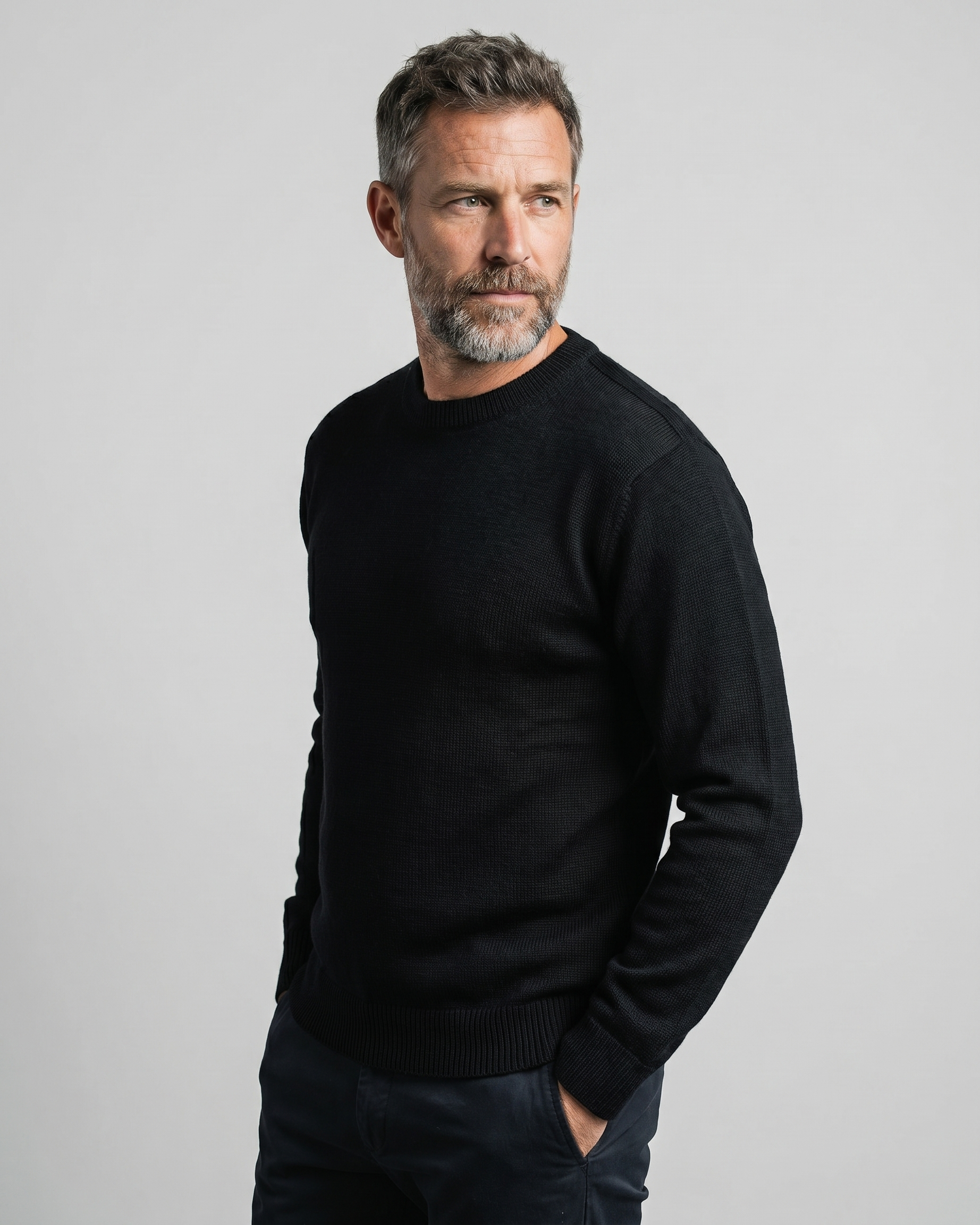 Man wearing a black sweater against a gray background