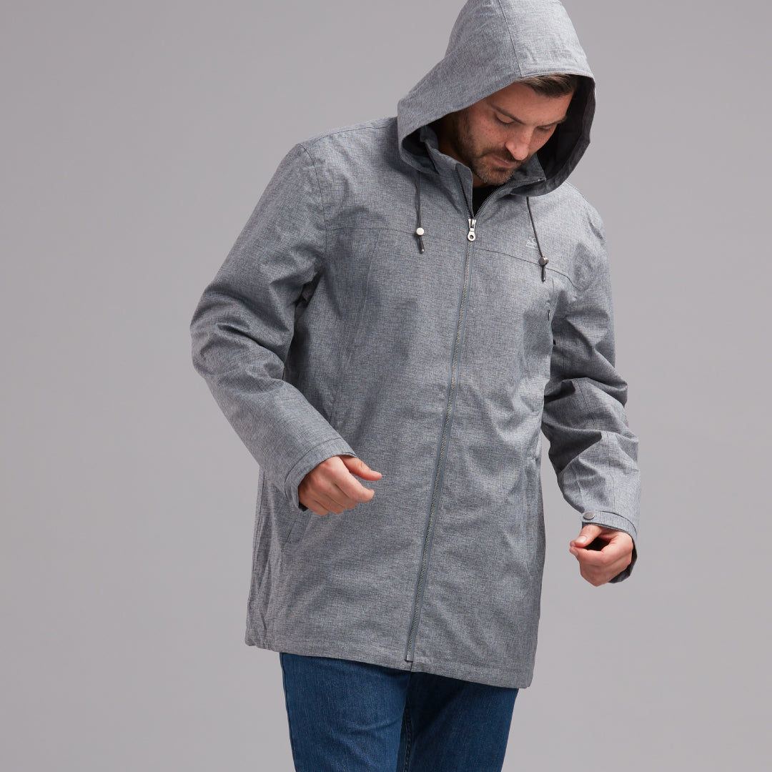 Dark haired man wearing a grey zip up jacket and jeans.