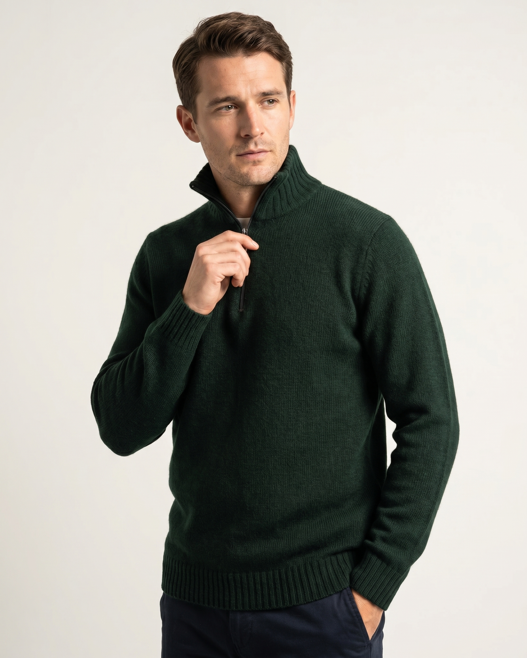 Man wearing a dark green quarter-zip sweater against a light background