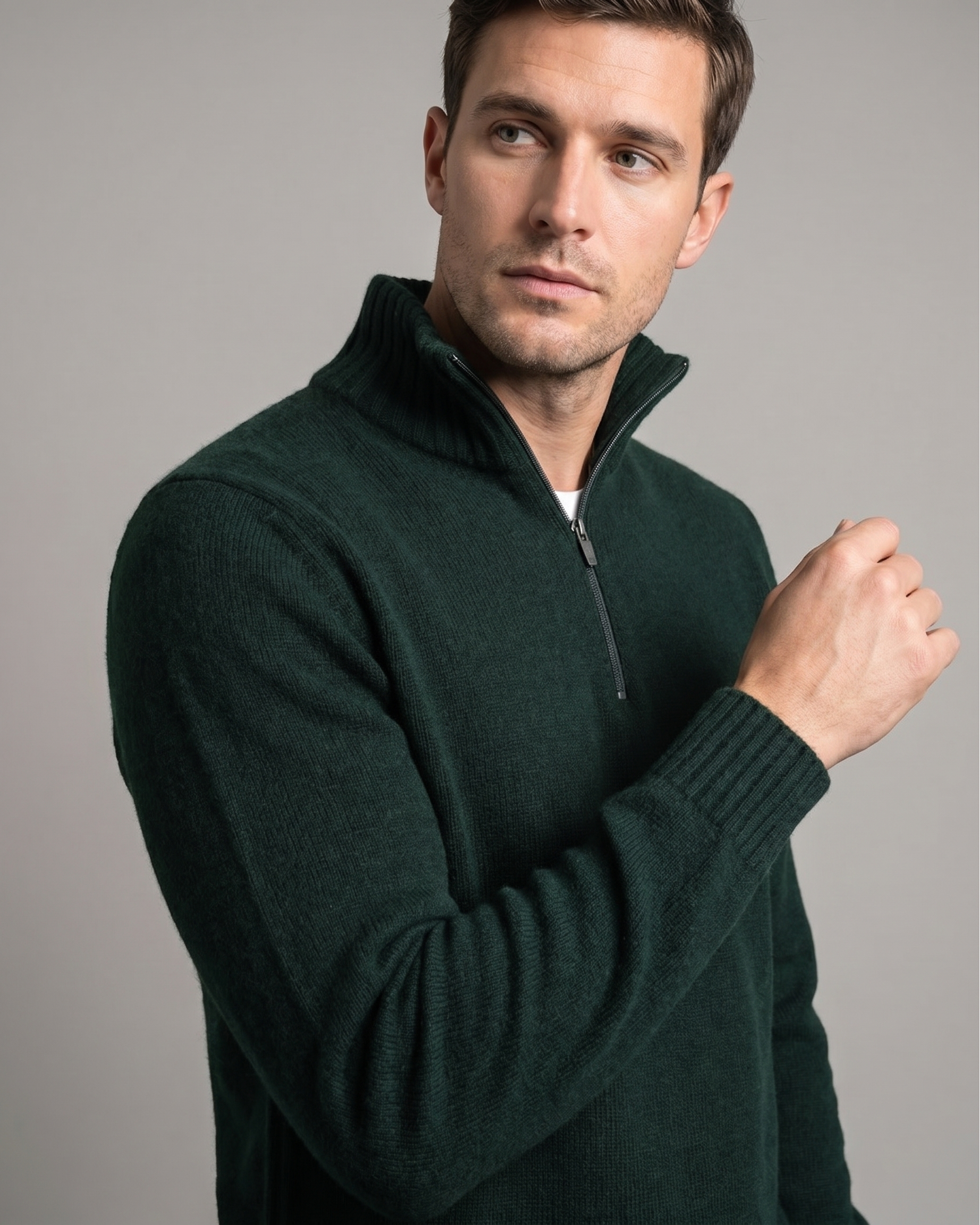 Man wearing a dark green quarter-zip pullover against a gray background