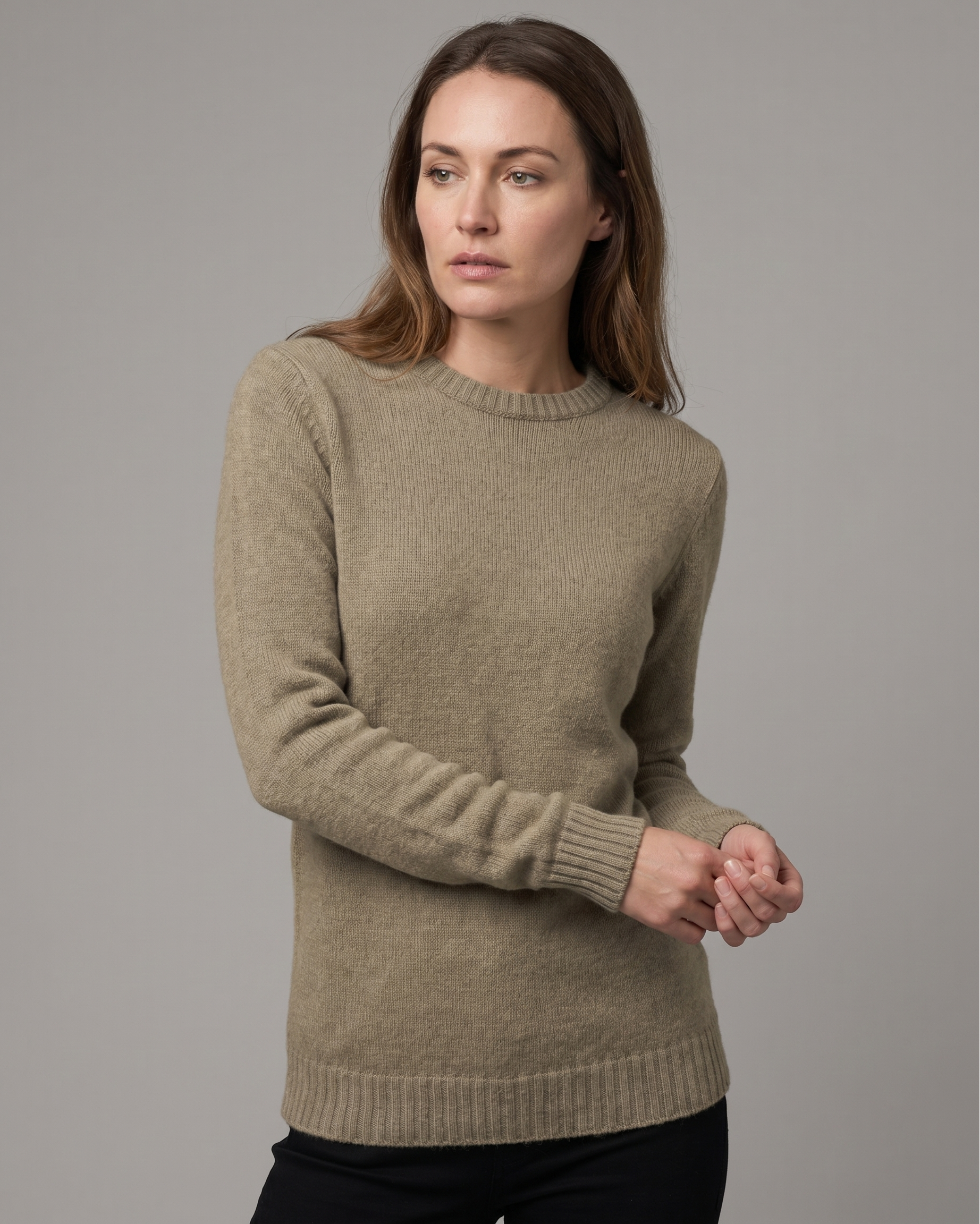 Woman wearing a beige sweater against a gray background