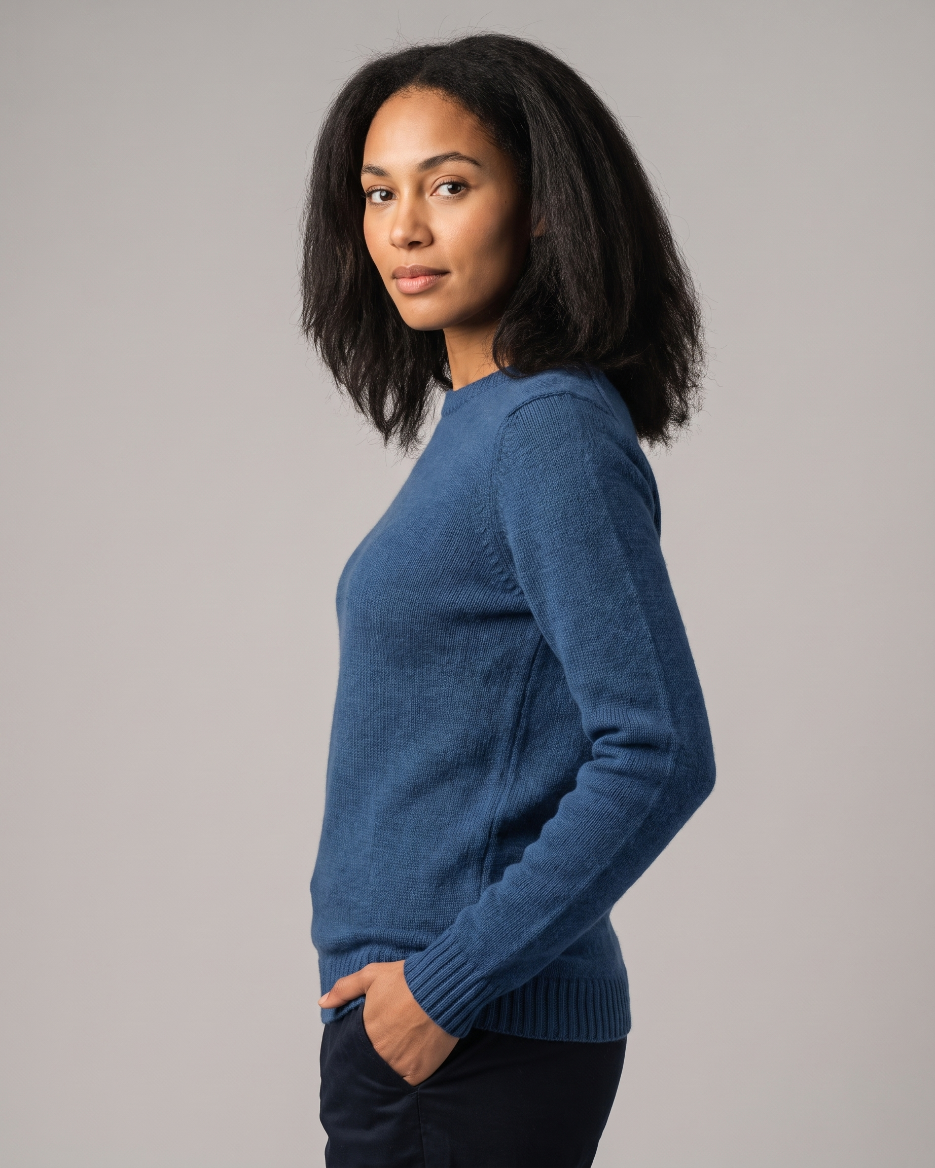 Woman wearing a pale blue sweater against a gray background