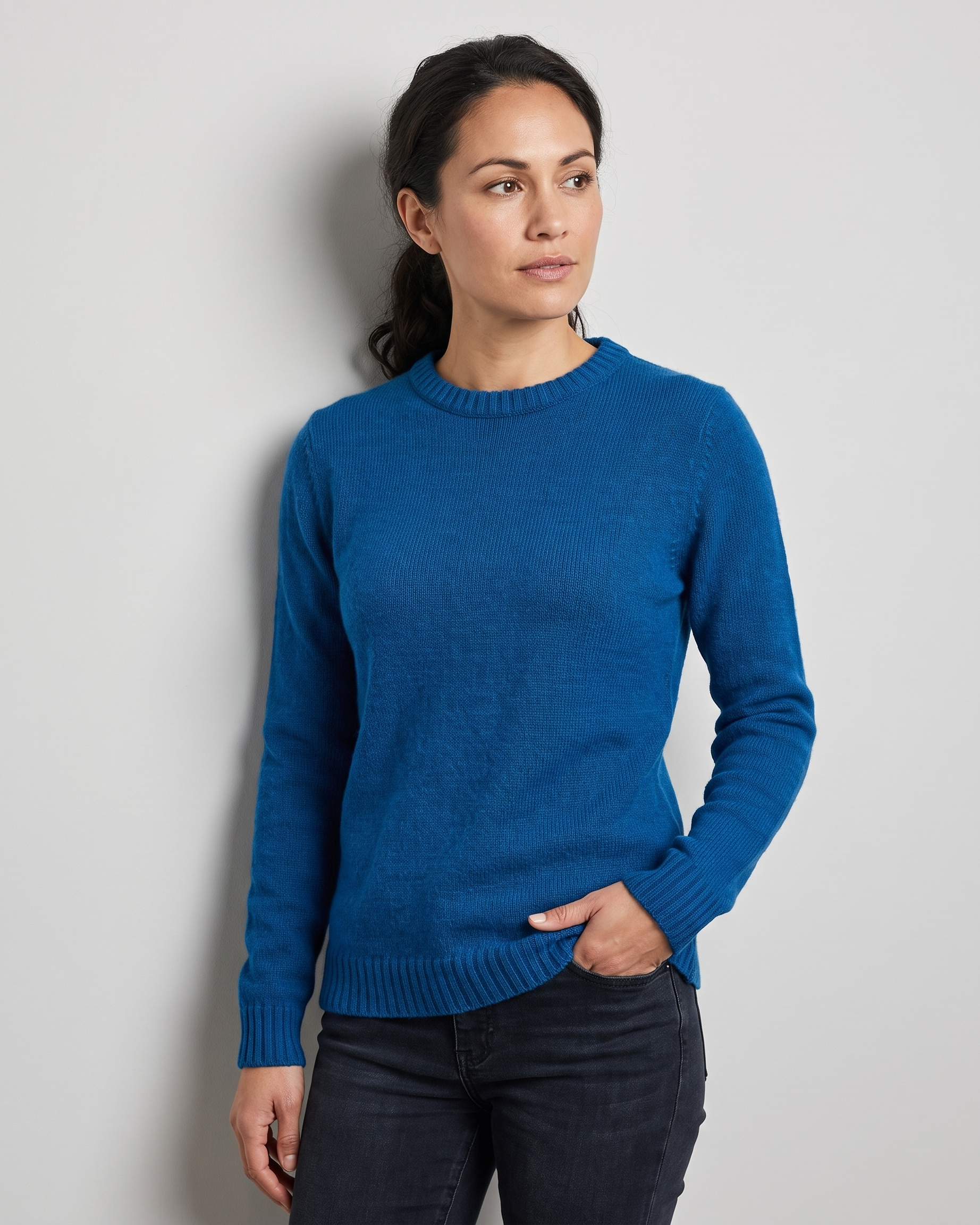 Woman wearing a blue sweater against a plain background