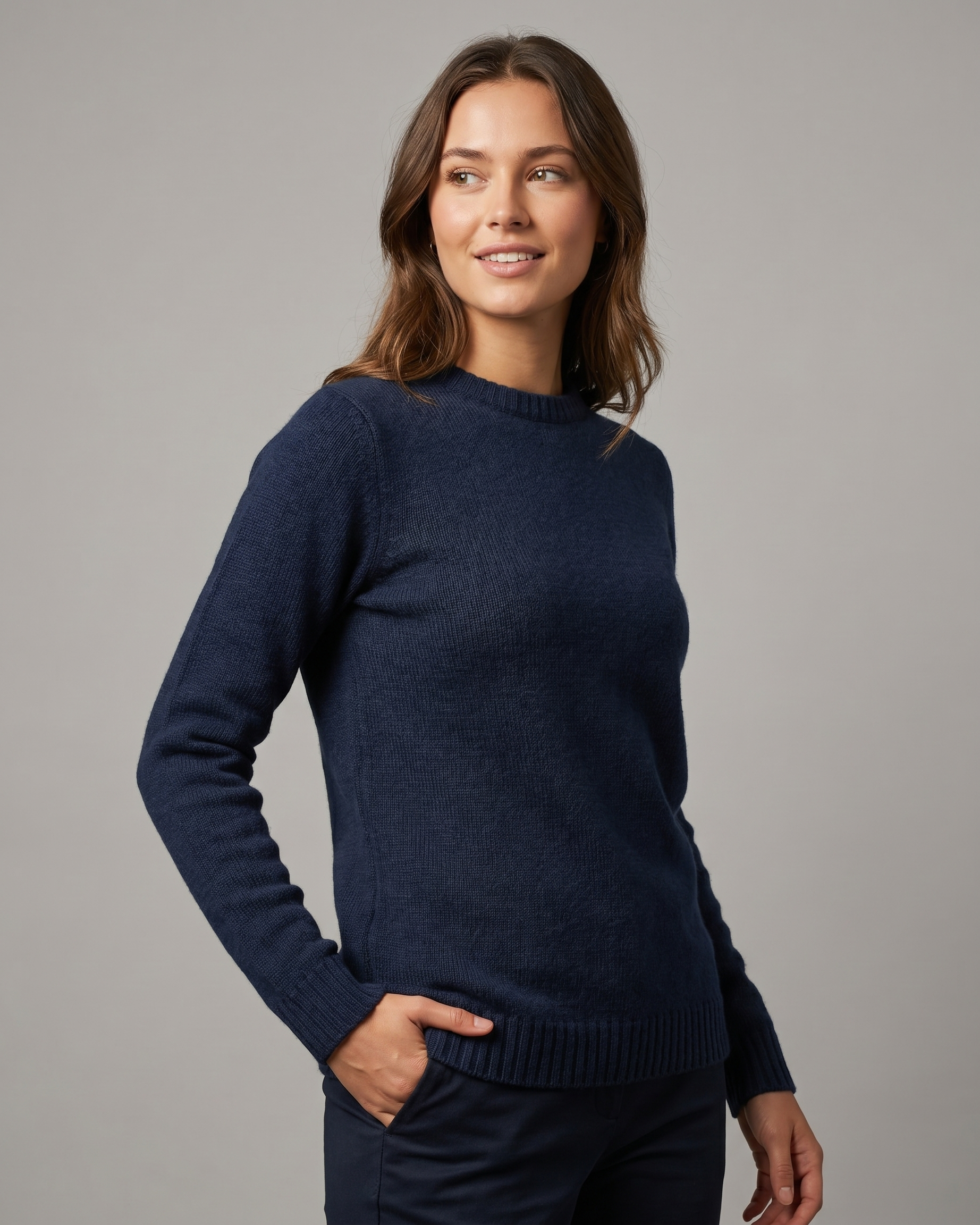 Woman wearing a navy sweater against a gray background