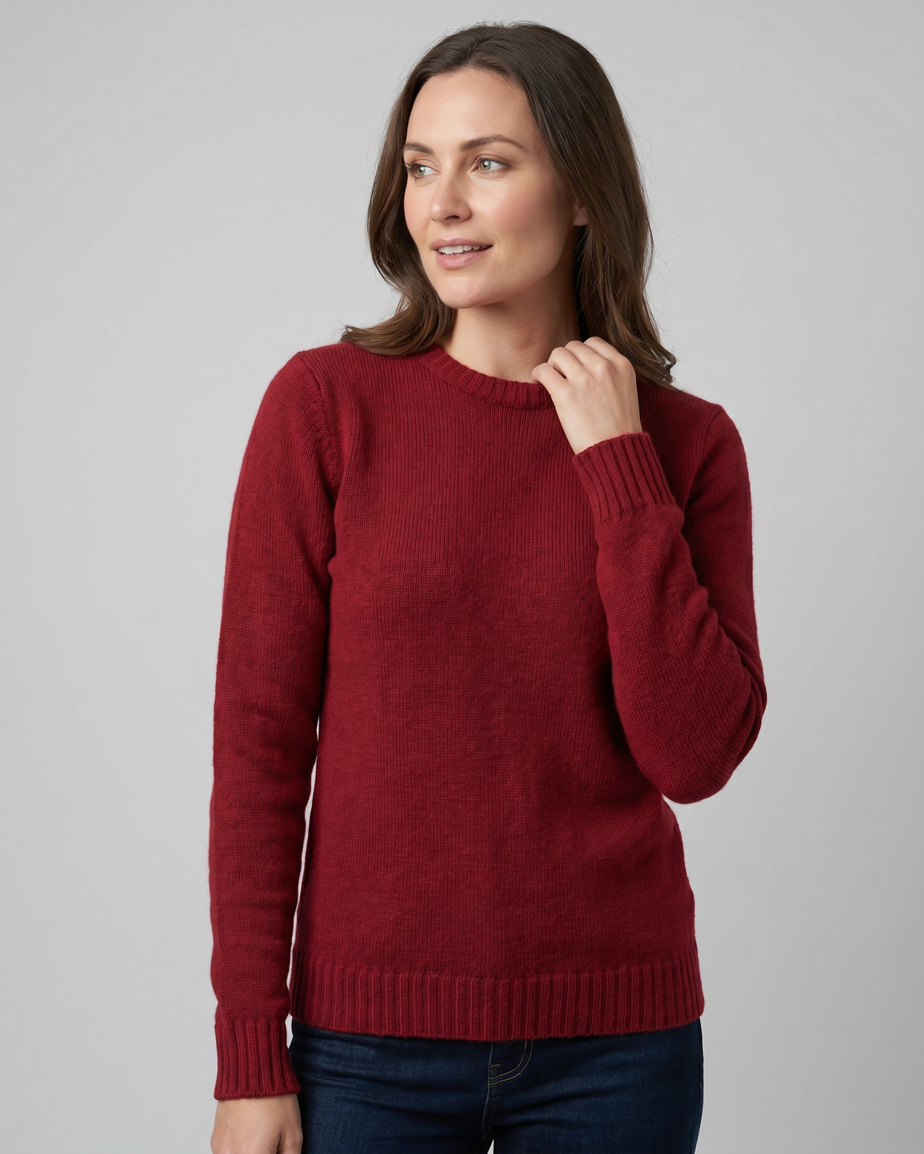 Woman wearing a red sweater against a gray background