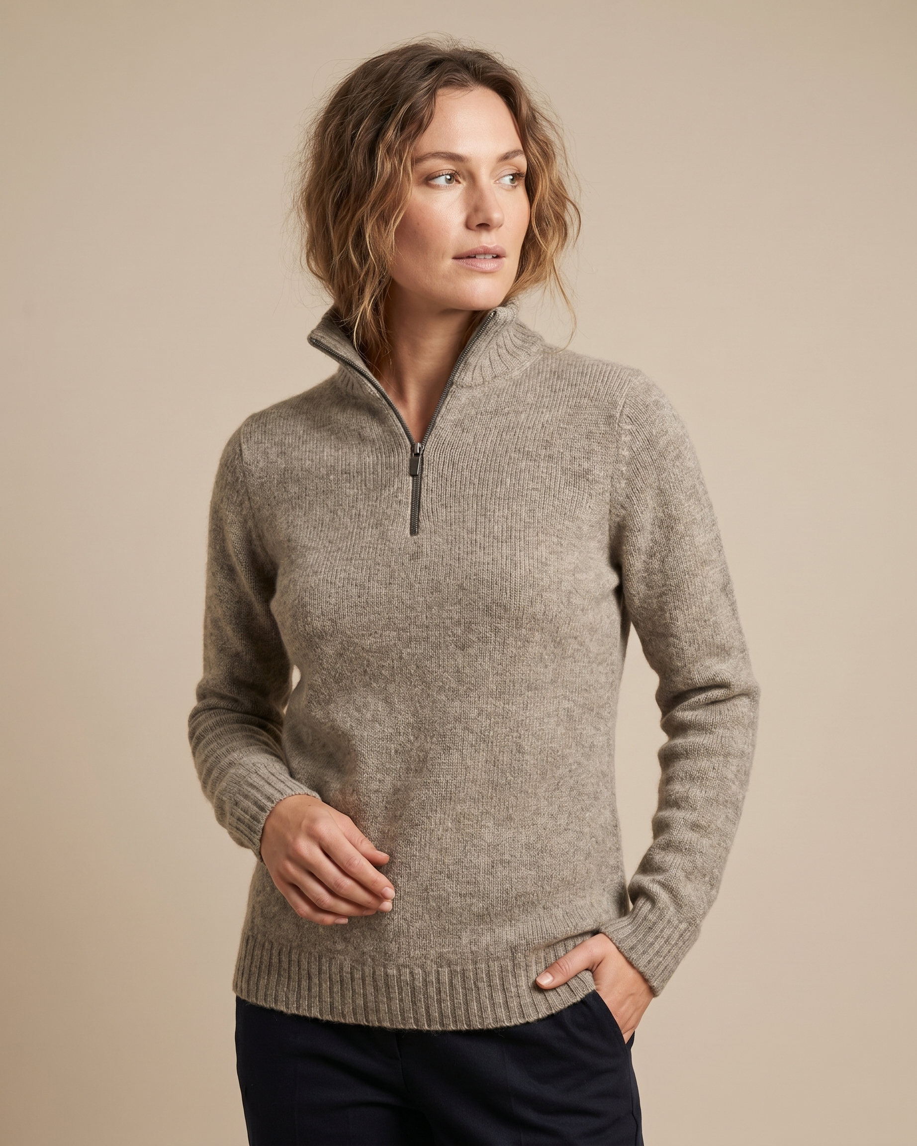 Woman wearing a oatmeal sweater with a zipper on a beige background