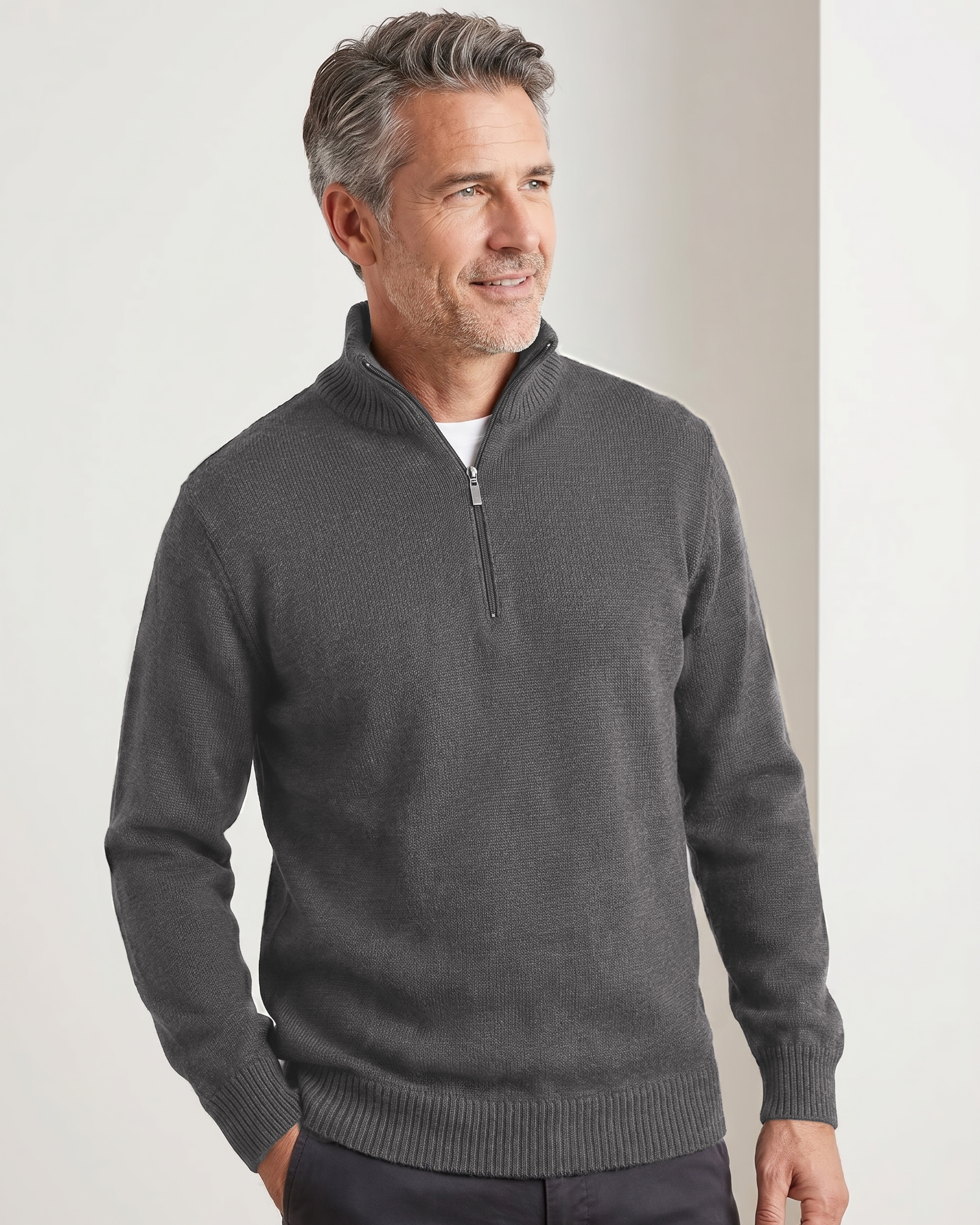 Man wearing a dark gray quarter-zip sweater against a plain background