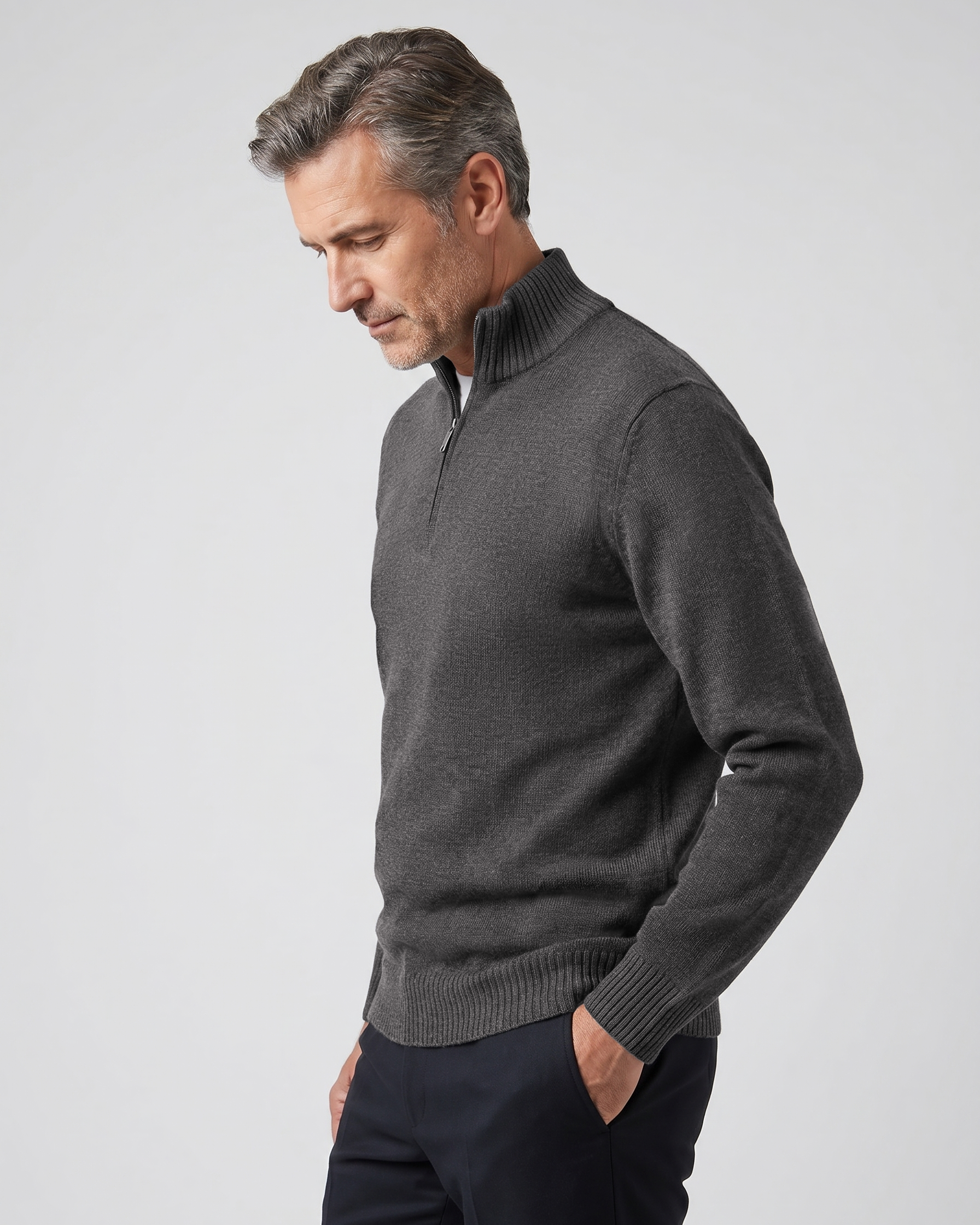 Man wearing a gray quarter zip sweater against a light gray background